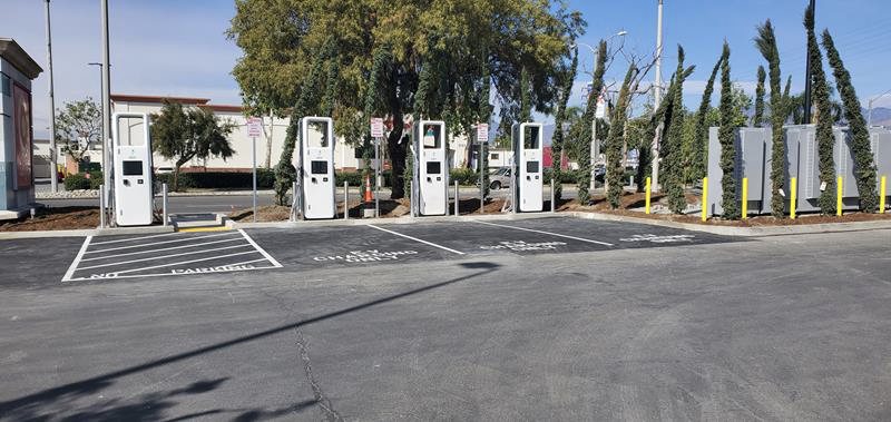 Row of DC fast-charging stations in a commercial parking lot