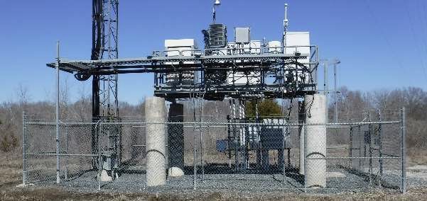 Elevated equipment platform with cabling and steel structure at a fenced compound
